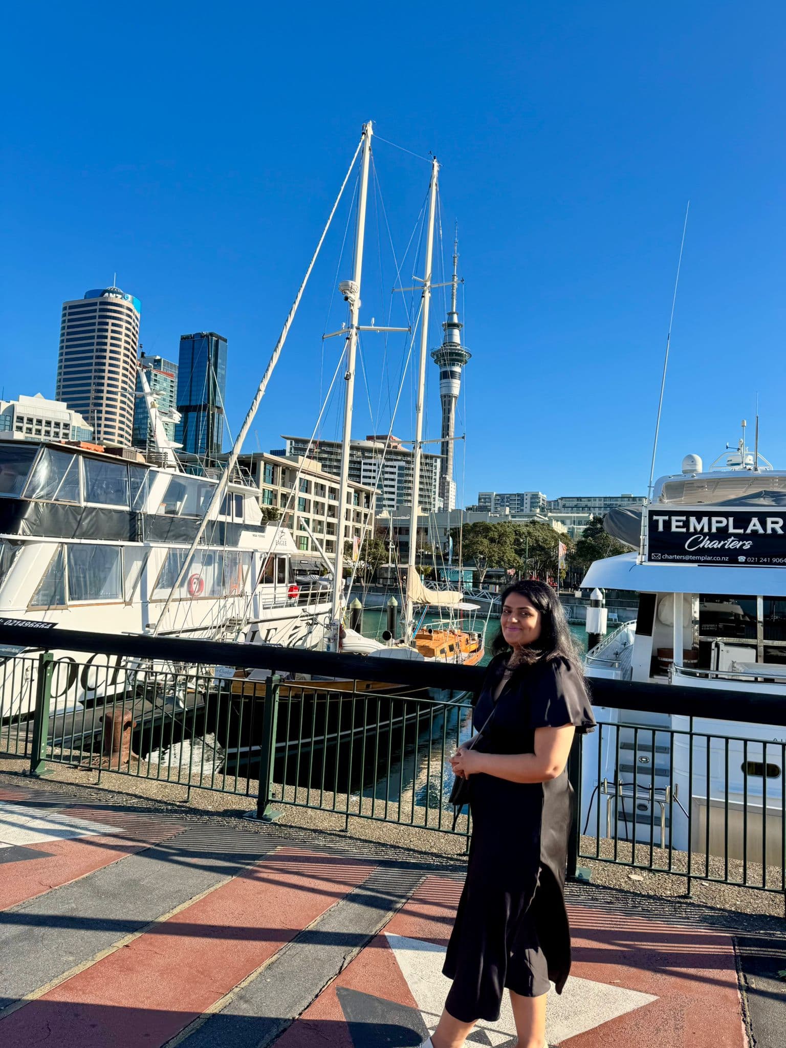 Anu on the Auckland waterfront with the city behind her